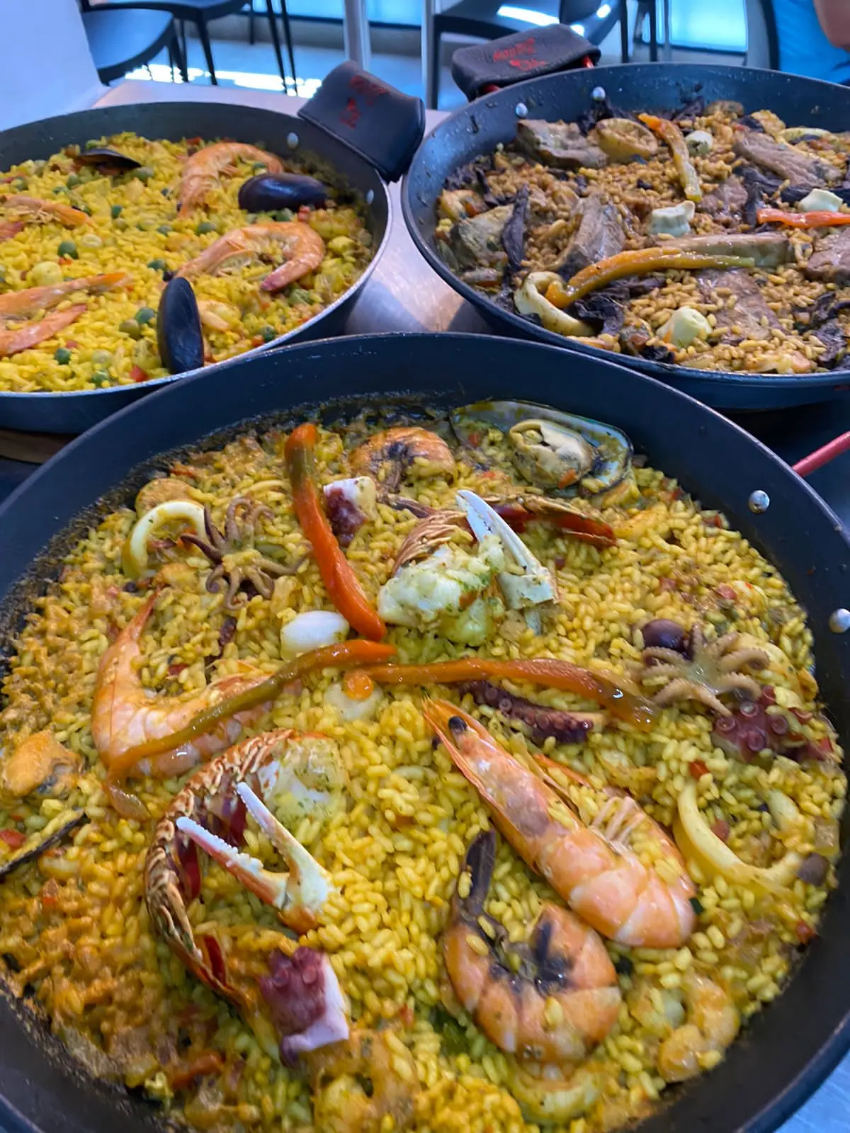 Three rice dishes prepared in a professional kitchen