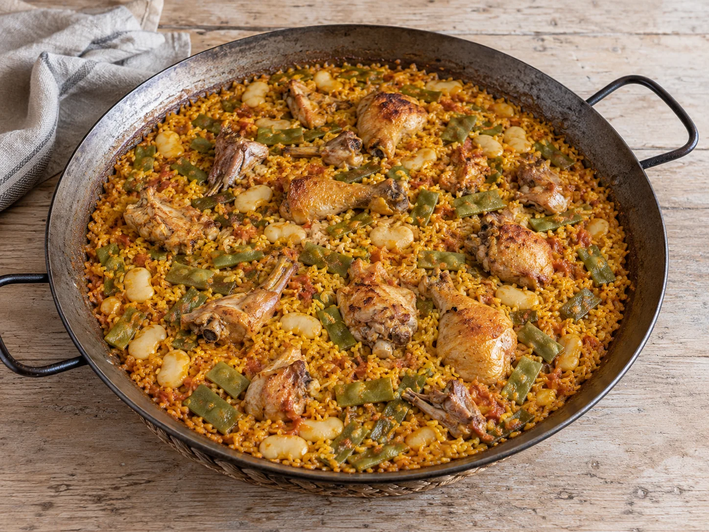 Ilustración de paella valenciana con pollo, conejo, judía verde y garrofón, sin caracoles